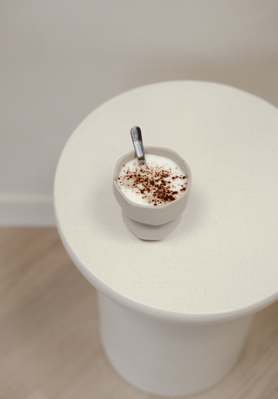 Cappuccino op een ronde bijzettafel in de salon