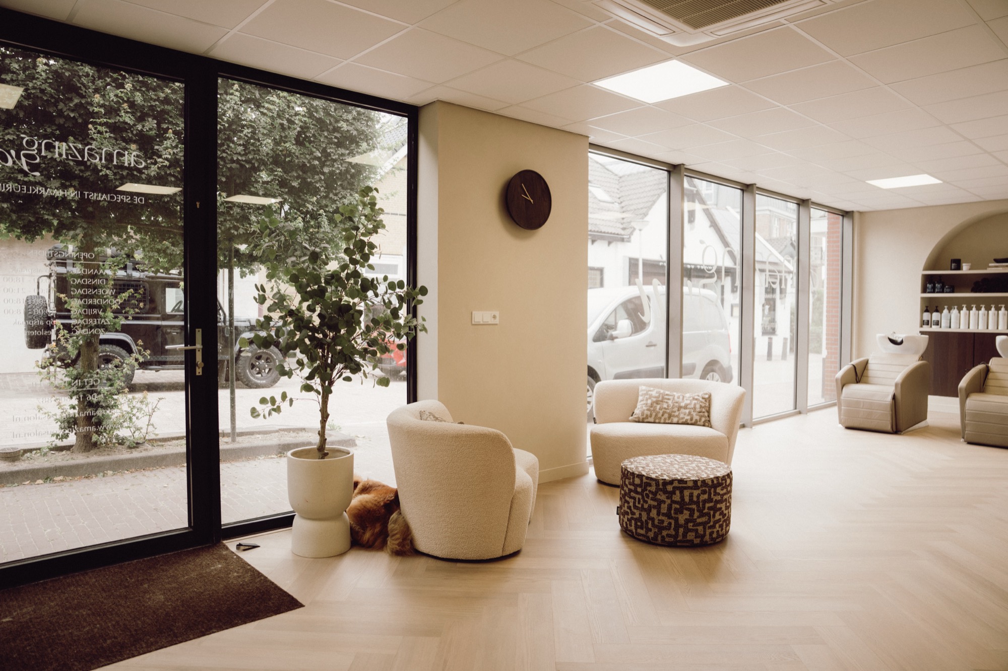 Lichte lounge met fauteuils en grote ramen